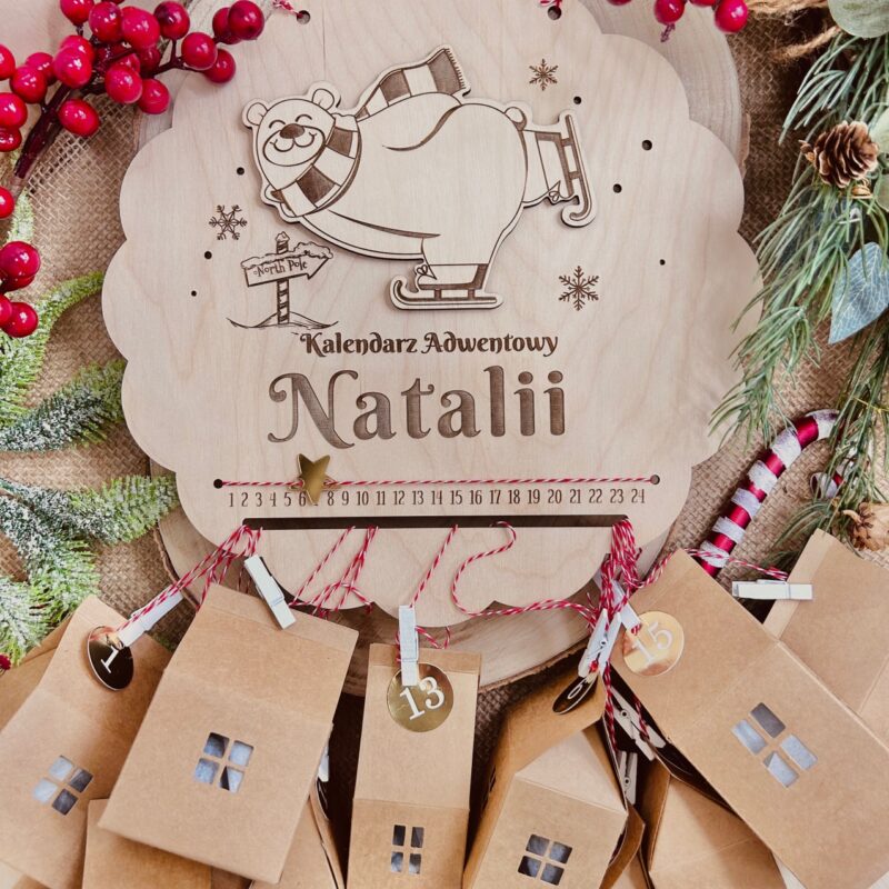 Kalendarz adwentowy w kształcie koła z misiem na łyżwach i domkami na sznurkach